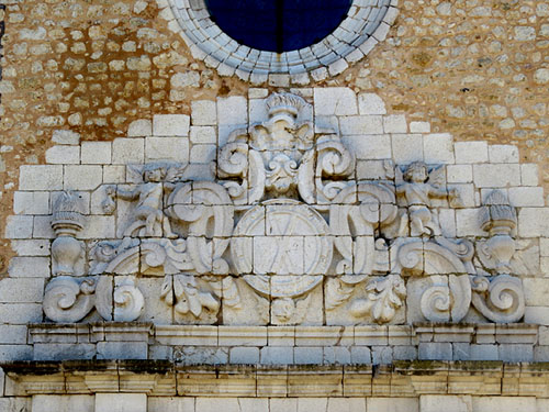 Façana de l'església de Sant Andreu. Frontó decoratiu en alt relleu amb motius vegetals i volutes de traça geomètrica, amb dos àngels