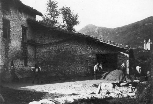 Gent treballant en una era de Creixenturri, al fons el Santuari del Remei de Camprodon. 1890-1923