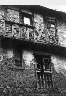 Part de la façana d'una casa amb tancaments de fusta al carrer de la Morena de Puigcerdà. 1931