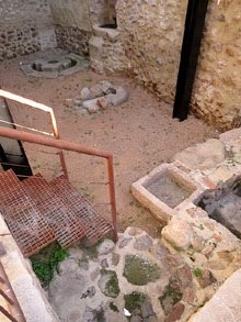 Espai arqueològic de Can Can Déu-Siau. Al fons s'observa la pedra de lliura o contrapès de la gran premsa de biga