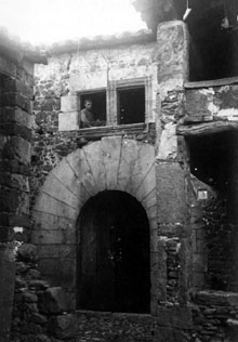 Façana d'una casa de Centenys amb portal i un nen a la finestra. Ca. 1927